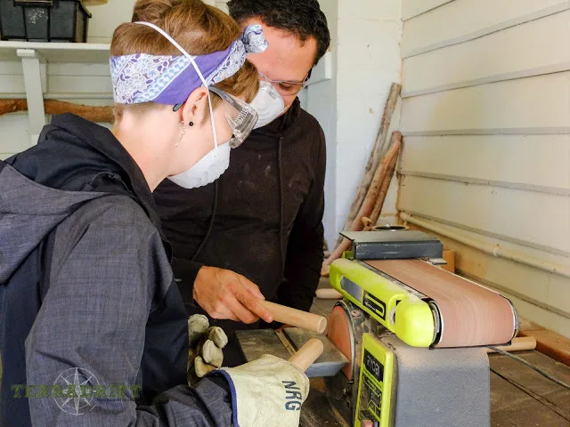 a man and woman bend over a work bench