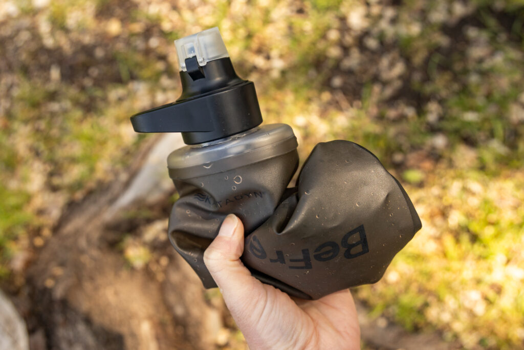 A Katadyn BeFree collapsible filter bottle is squished up in a hand.