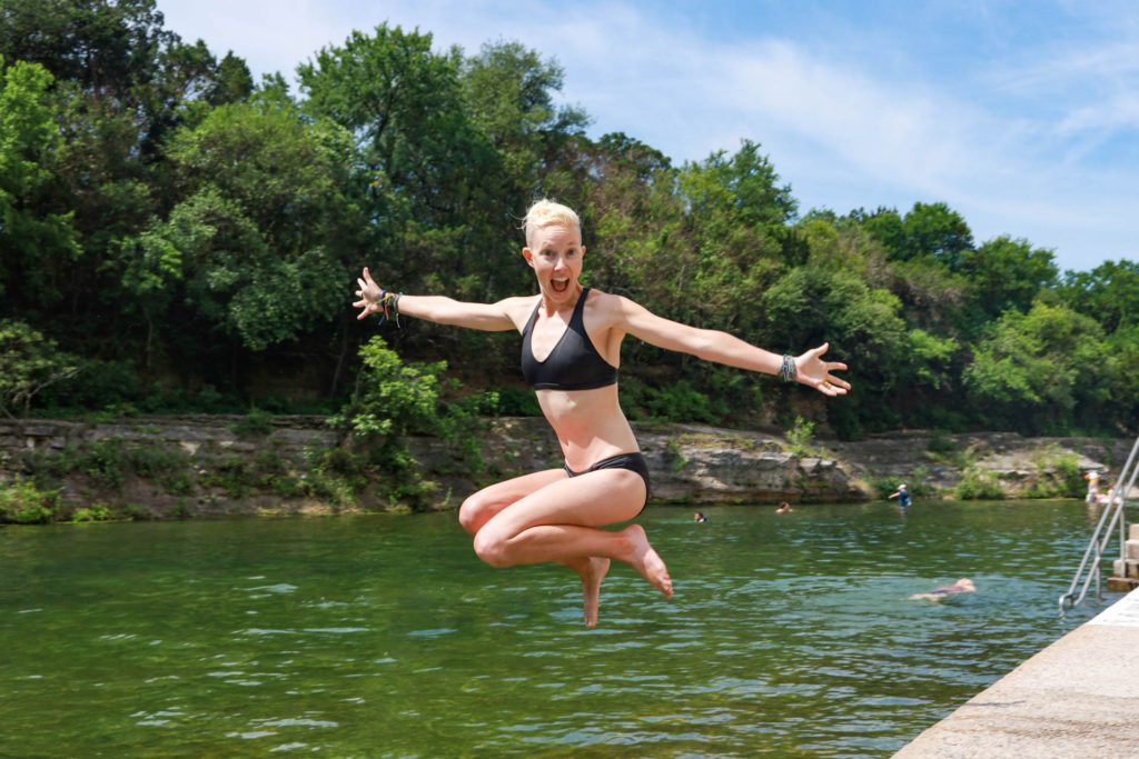 Jumping into Barton Springs Pool in my Patagonia sustainable swimsuit.