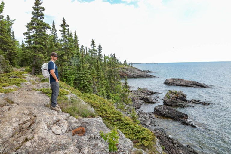 A man looks out at the water on Isle Royale.