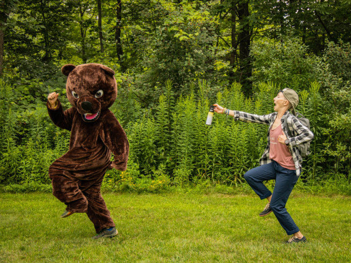 Alisha chasing a person in a bear costume with bear spray.