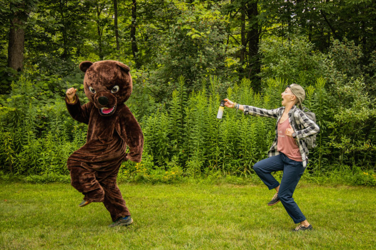 Alisha chasing a person in a bear costume with bear spray.