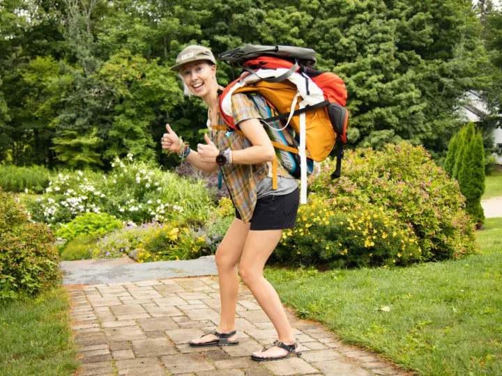 A woman carrying a stack of sustainable day packs