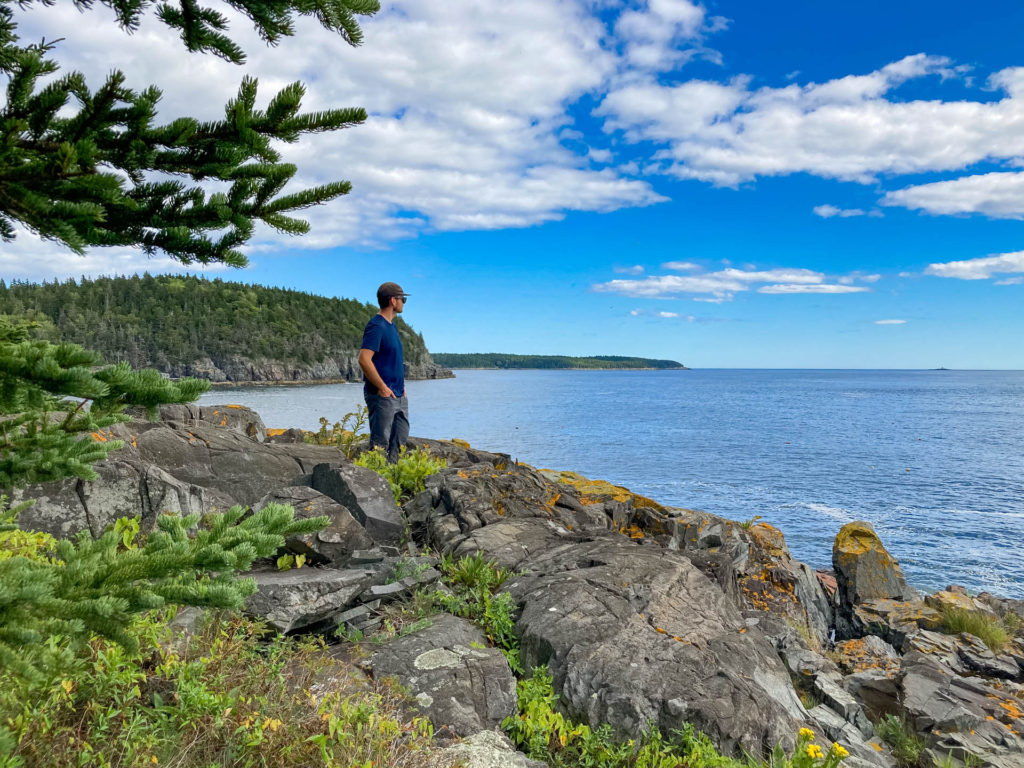 A man looks out over the bay from Rum Key off the coast of Acadia National Park.