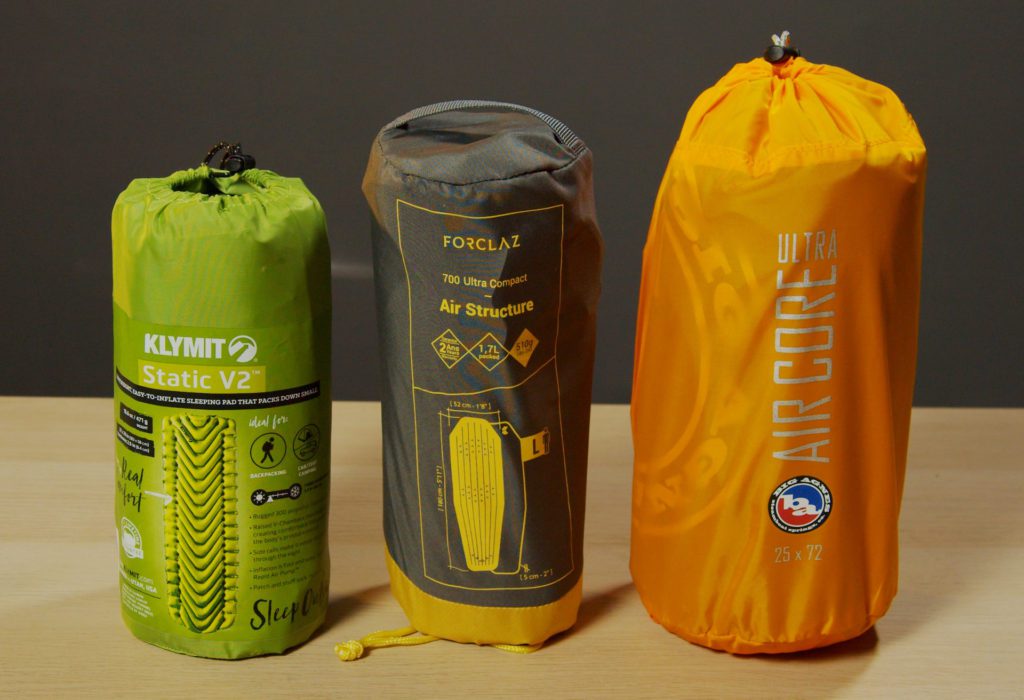 The Klymit Static V2, Decathlon Forclaz 700, and Big Agnes Air Core Ultra inflatable sleeping pads in their stuff sacks.