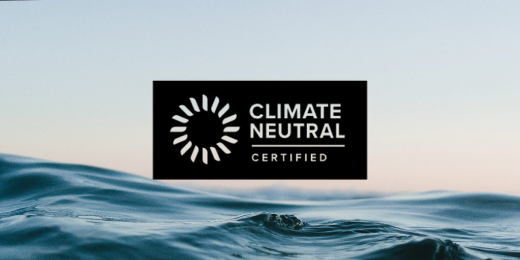 Climate Neutral logo with a sunset over water in the background.