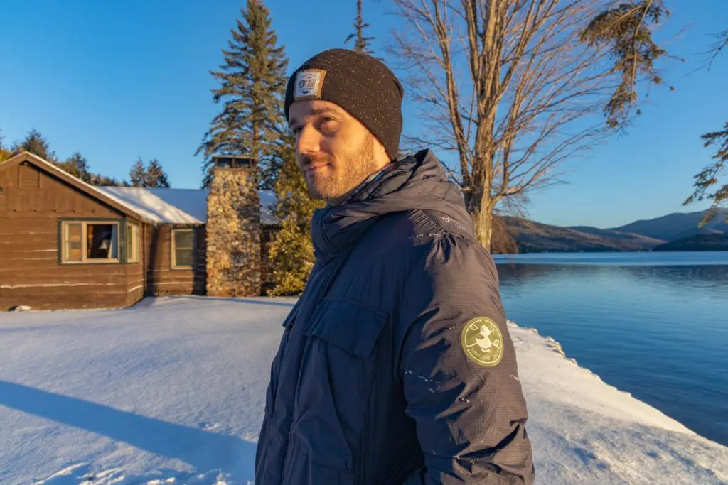 Man in a Save the Duck biodegradable coat in front of Lake Placid.