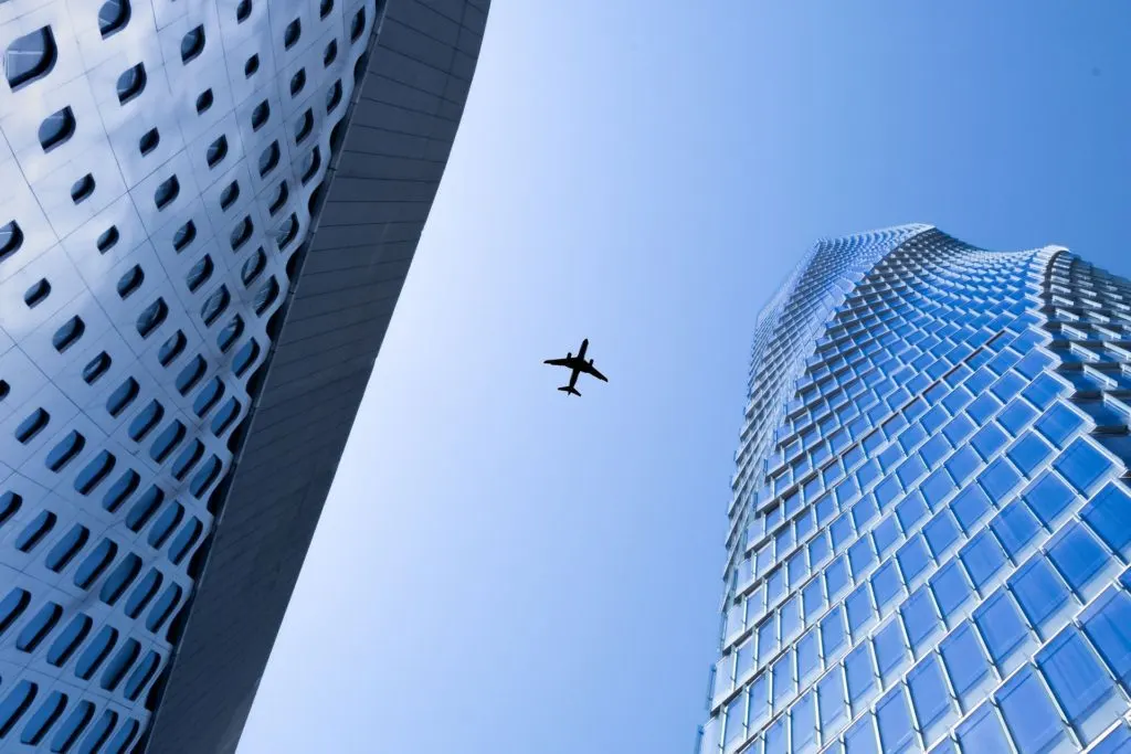 An airplane in the sky above skyscrapers.