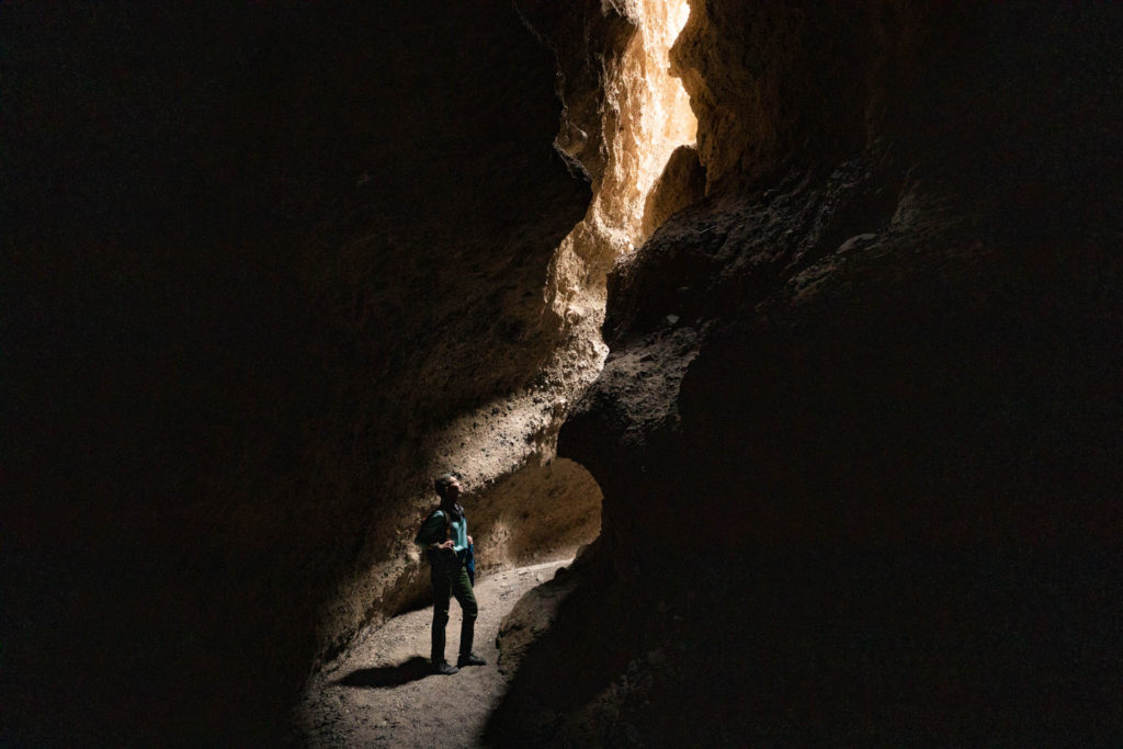 woman in the wan light of a slot canyon in Death Valley National Park.