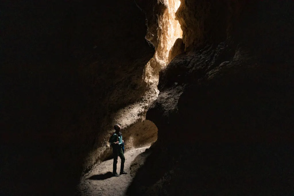 woman in the wan light of a slot canyon in Death Valley National Park.