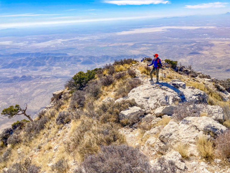 woman standing on the peak of Guadalupe Peak.
