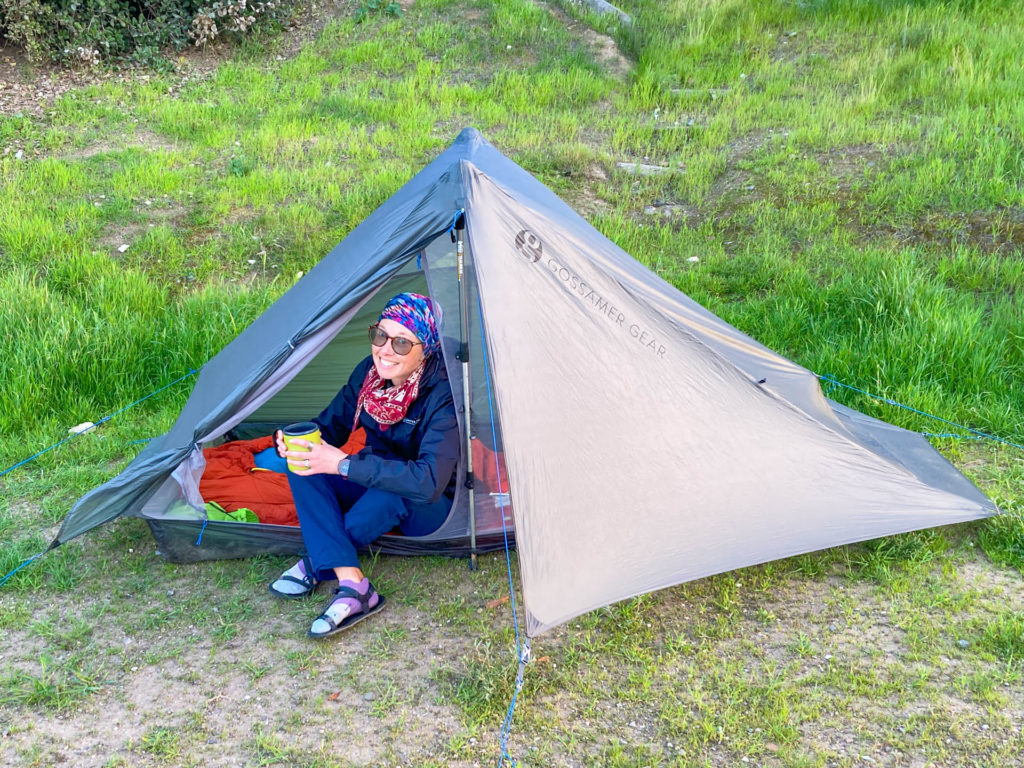 A woman with a mug inside the spacious The One ultralight tent from Gossamer Gear.