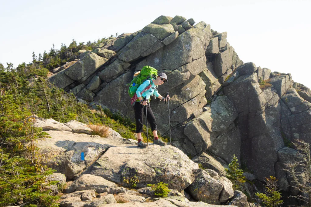A woman with a backpack looking tired on the Pemiwegasset Loop in the White Mountains.