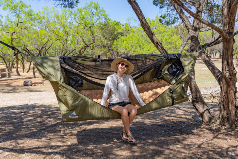 Woman sitting in the Haven Safari Lay-flat Hammock.