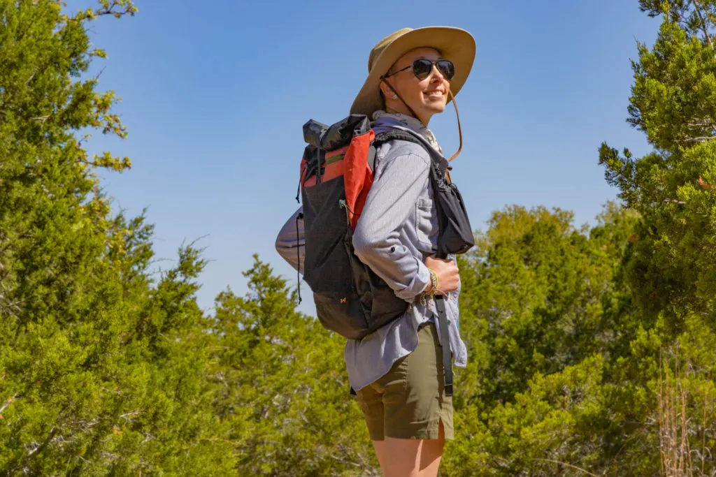 A woman sporting the Waymark Gear Co. MILE 28 backpack in Red Rock.