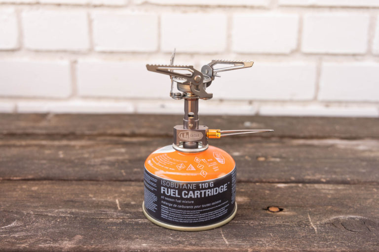 A backpacking stove connected to a fuel canister.