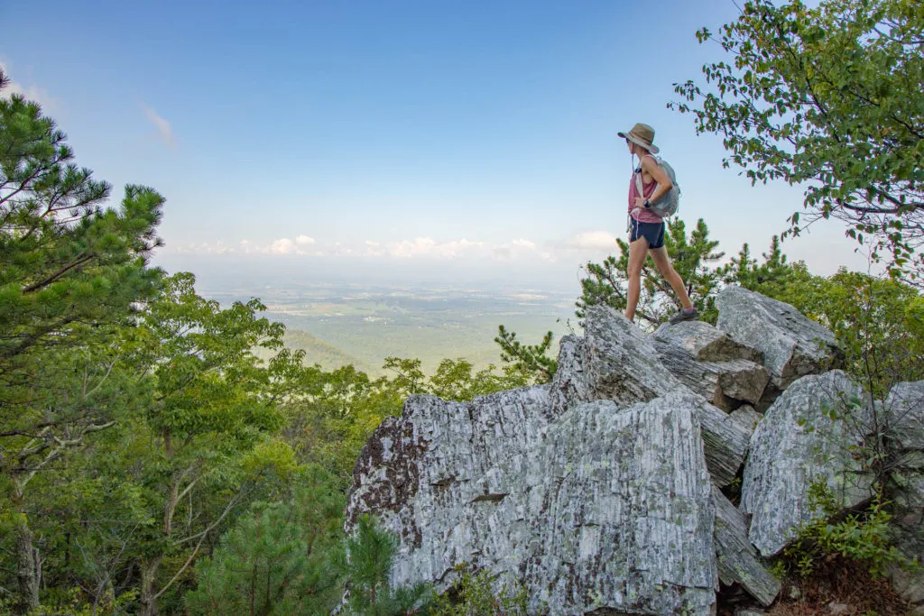 Woman standing on a cliff with a backpack in Shenandoah National Park