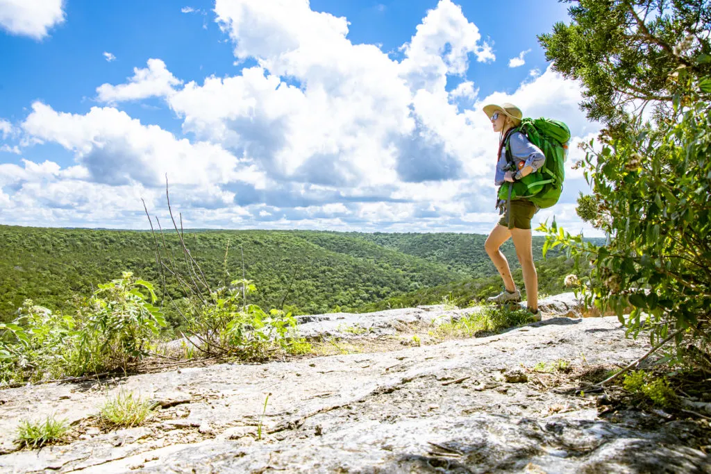 A woman solo backpacking in Lost Maples State Park in Texas.