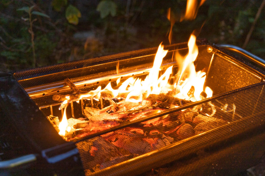 A small fire burning in the BioLite FirePit+ smokeless fire pit.