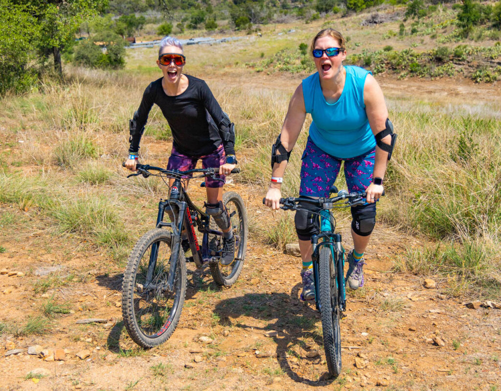 Two women mountain biking in SHREDLY apparel.