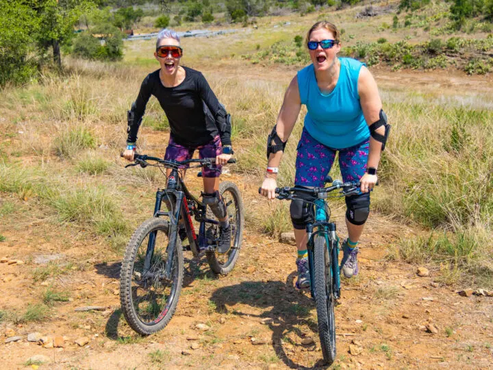 Two women Mountain biking in SHREDLY mountain bike clothing.