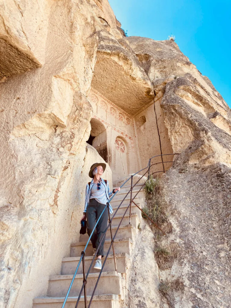 A woman comes down the stairs at the Goreme Open Air Museum in Cappadocia, Turkey.