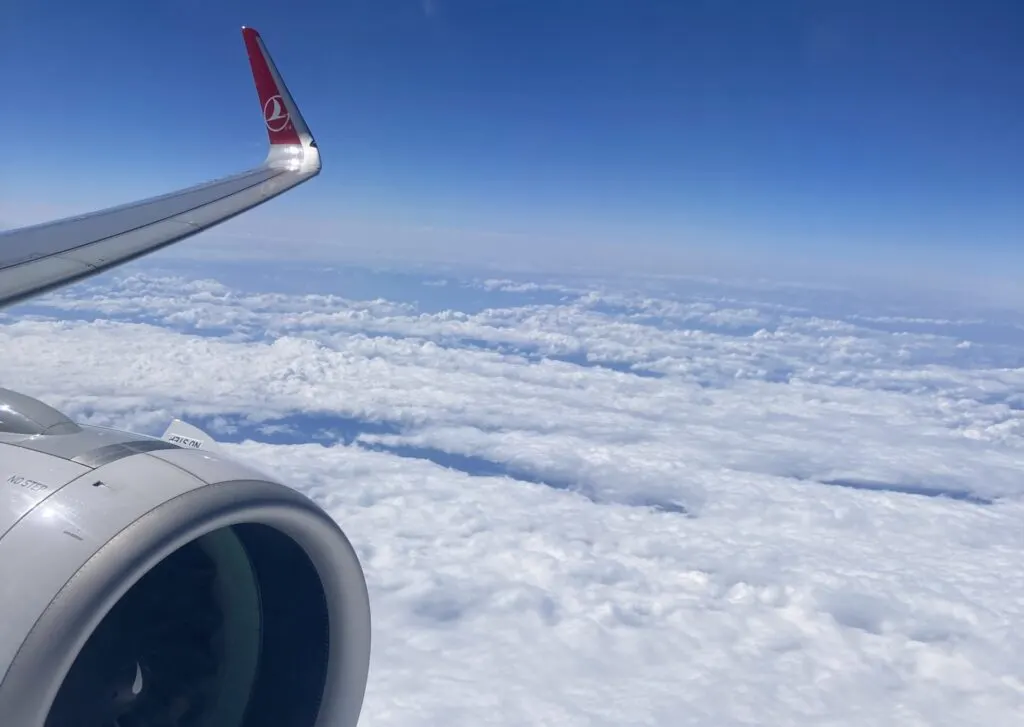 A view out of an airplane window: above the clouds.