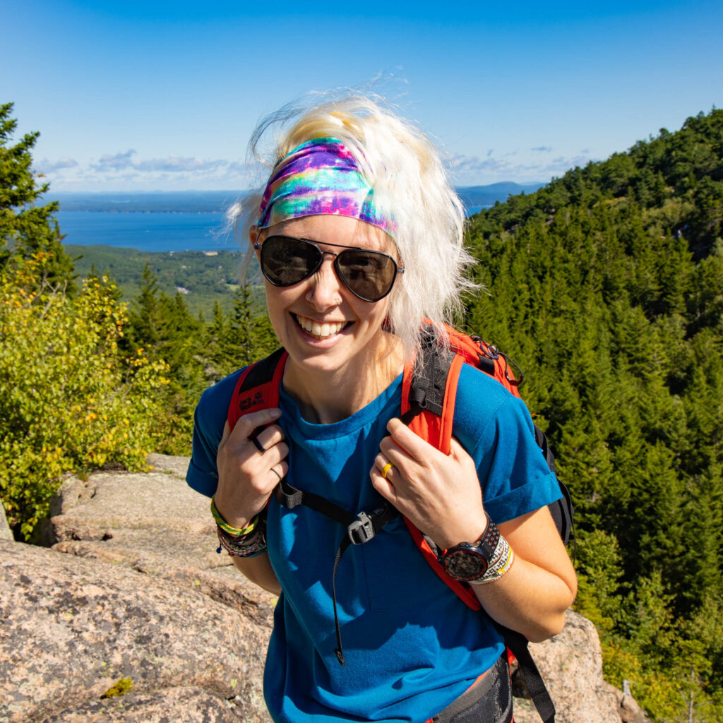 A woman in the mountains wears a HeadPeace headband.