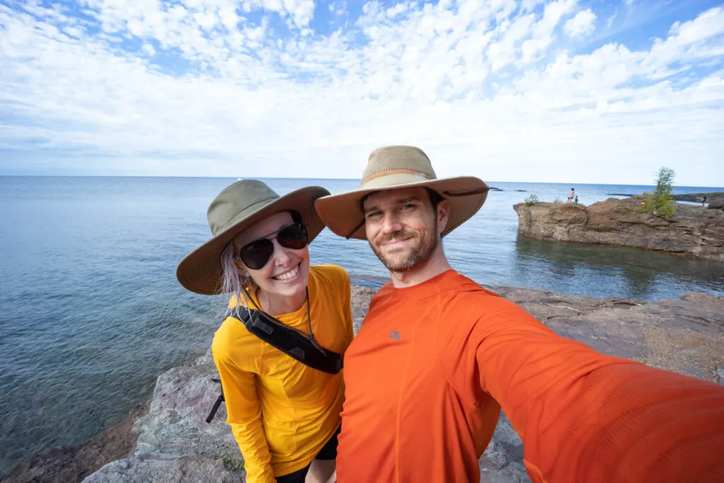 a man and woman by the lake at Black Rocks in Presque Isle Park in Marquette, Michigan.