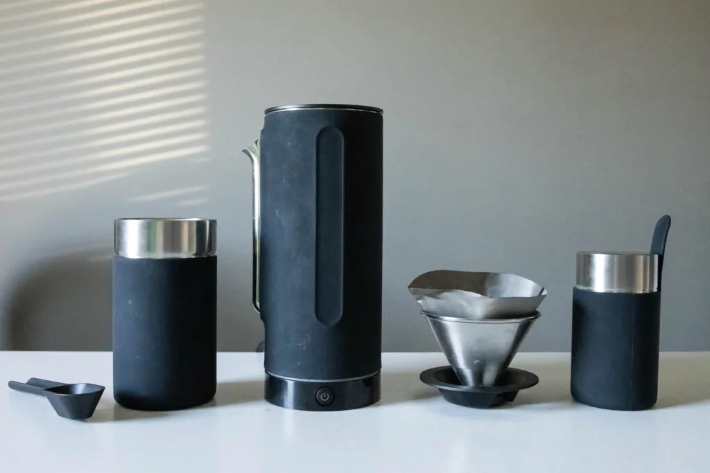 The Pakt Coffee Kit, including coffee scoop, travel mug, kettle, drip cone and reusable filter, and coffee canister.