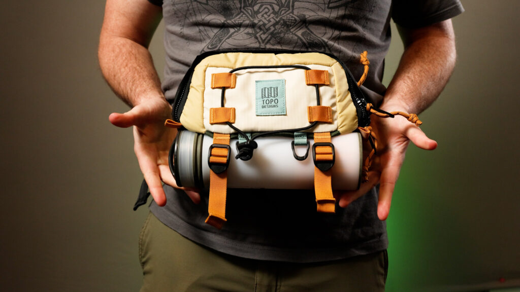 the Topo Designs Mountain Hip Pack with a water bottle strapped to the outside.