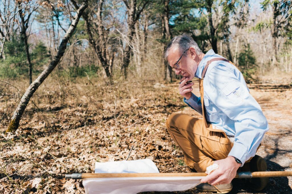 Dr. Thomas Mather studing ticks in the field.