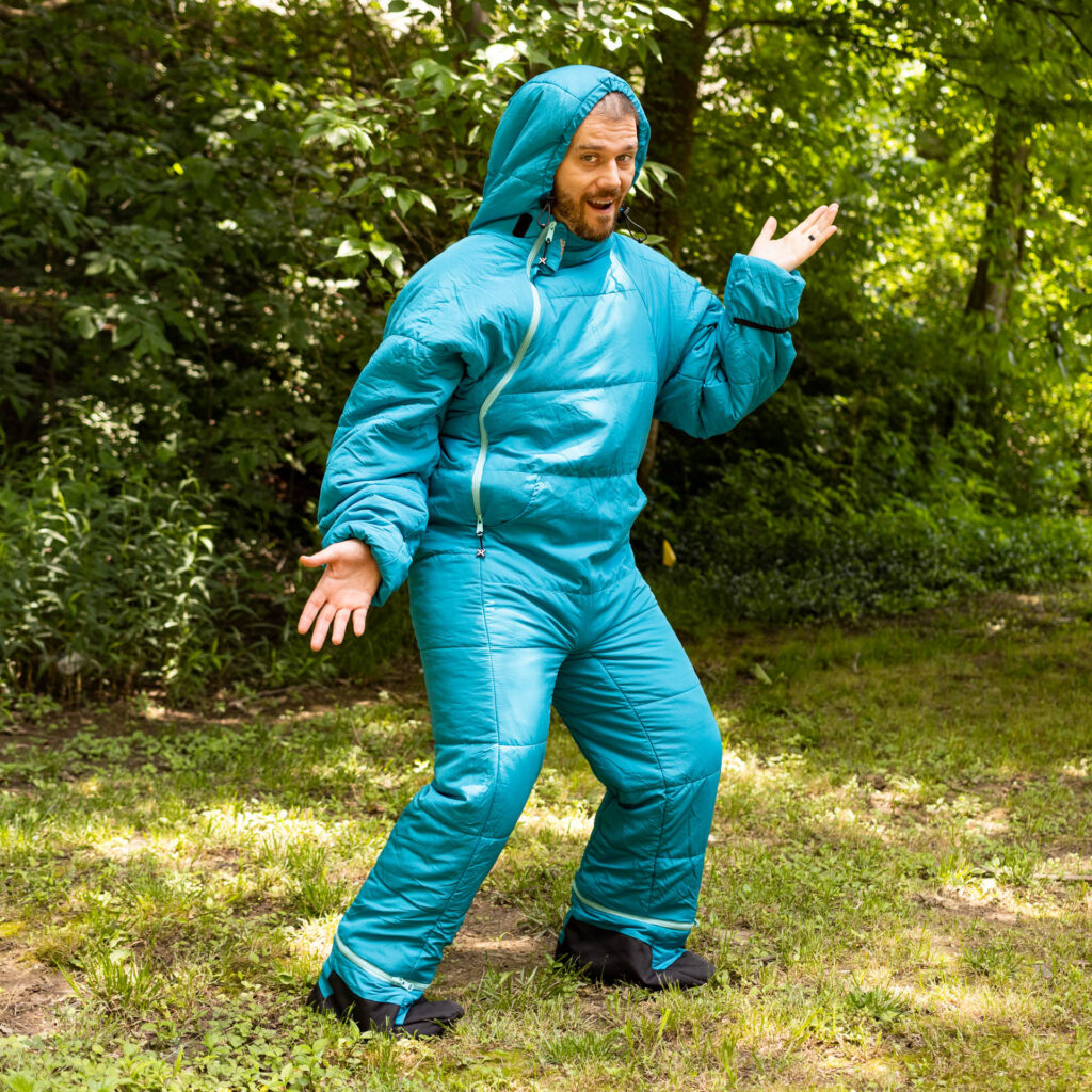 A man poses outdoors in a turquoise Selk'Bag.