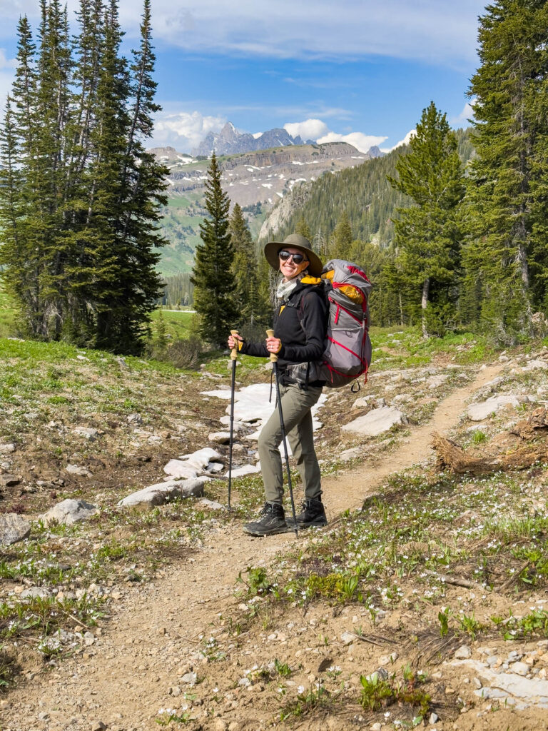 A woman smiles while backpacking in Grand Teton National Park.