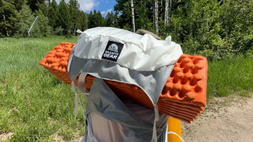 A foam sleeping pad strapped to the top of the Granite Gear Crown 3 60L backpack.