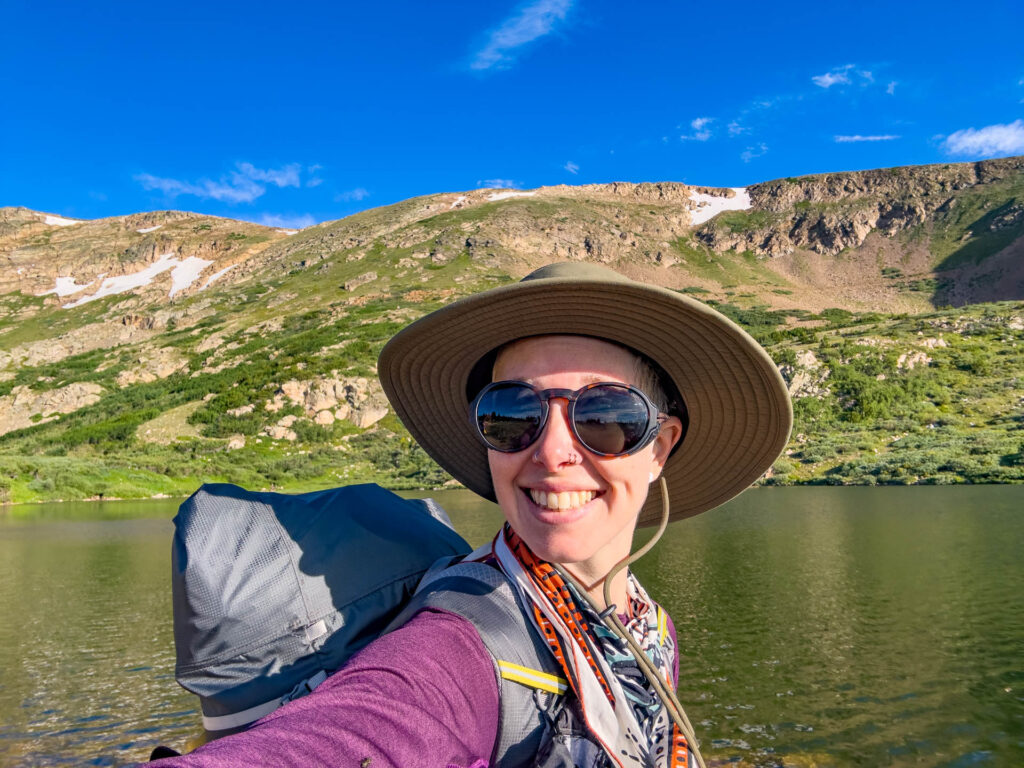 The Fjallraven Classic USA: Backpacking in Colorado and smiling next to an alpine lake.