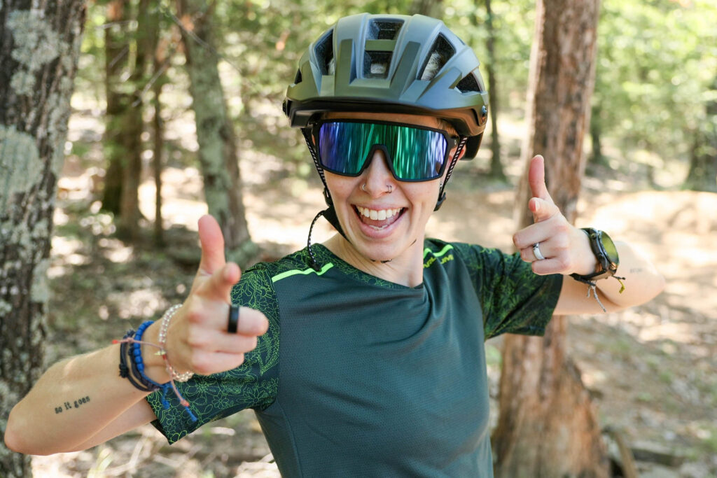 A woman smiles in a mtb helmet.