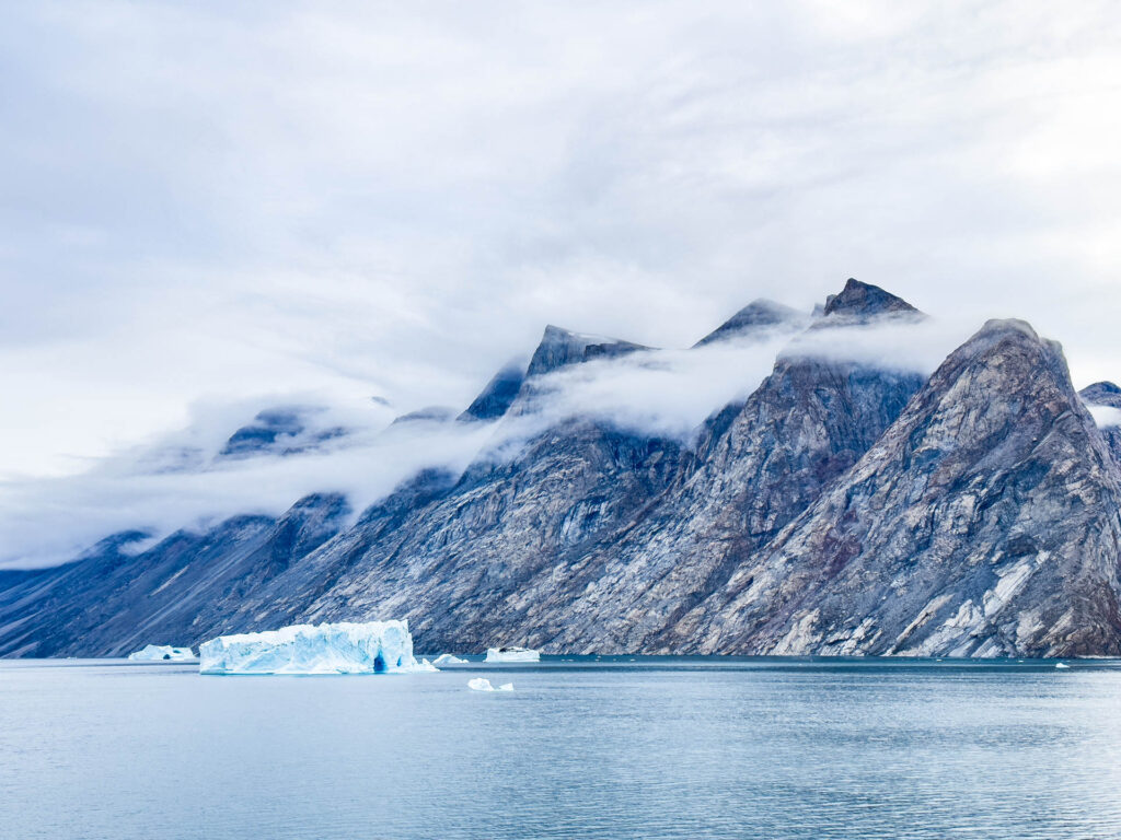 A view of cloud-swaddled mountains and a massive iceberg from the ship.