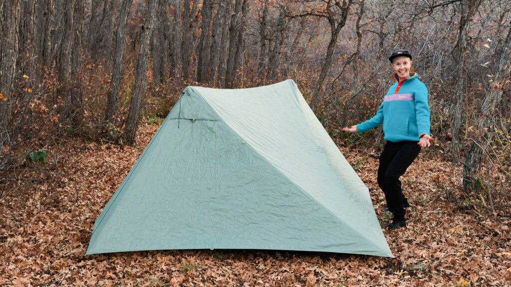 A woman stands next to the fully pitched Durston X-Mid 2 ultralight backpacking tent.