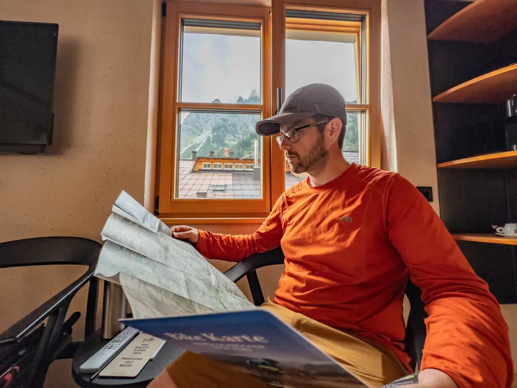 A man looks at a map by a window.