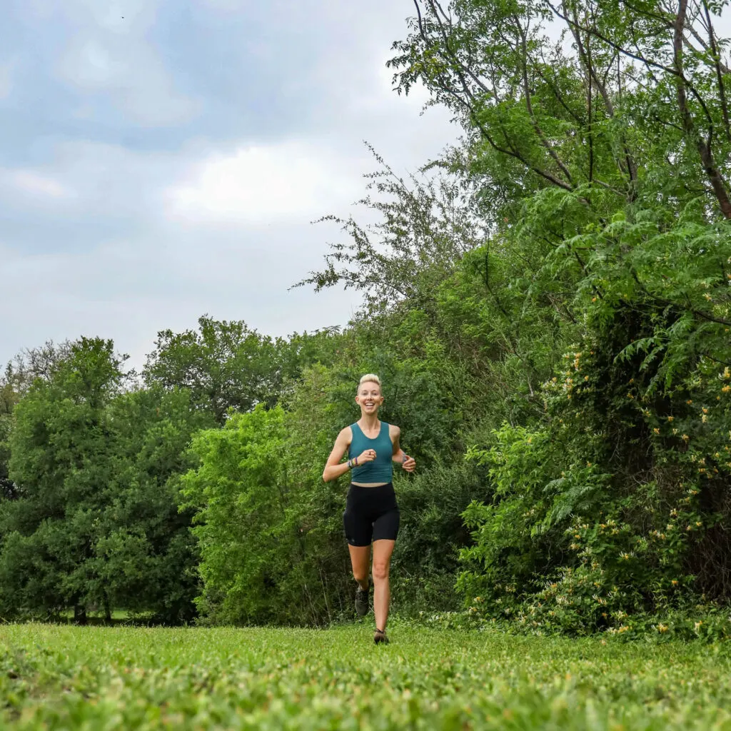 A woman runs in a Janji crop sports bra.