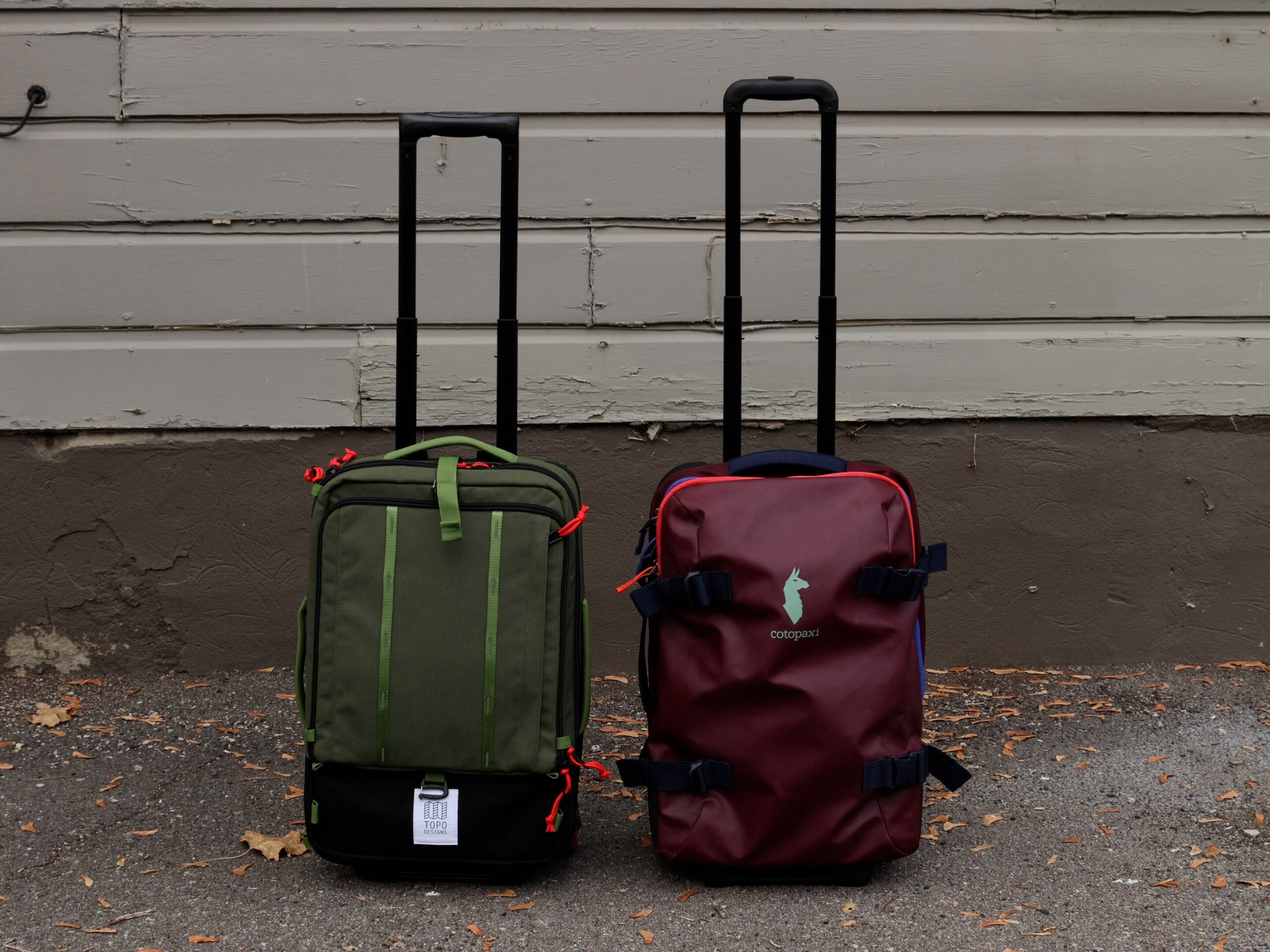 The Topo Designs carry-on bag (left) and the Cotopaxi Allpa (right) with handles fully extended.
