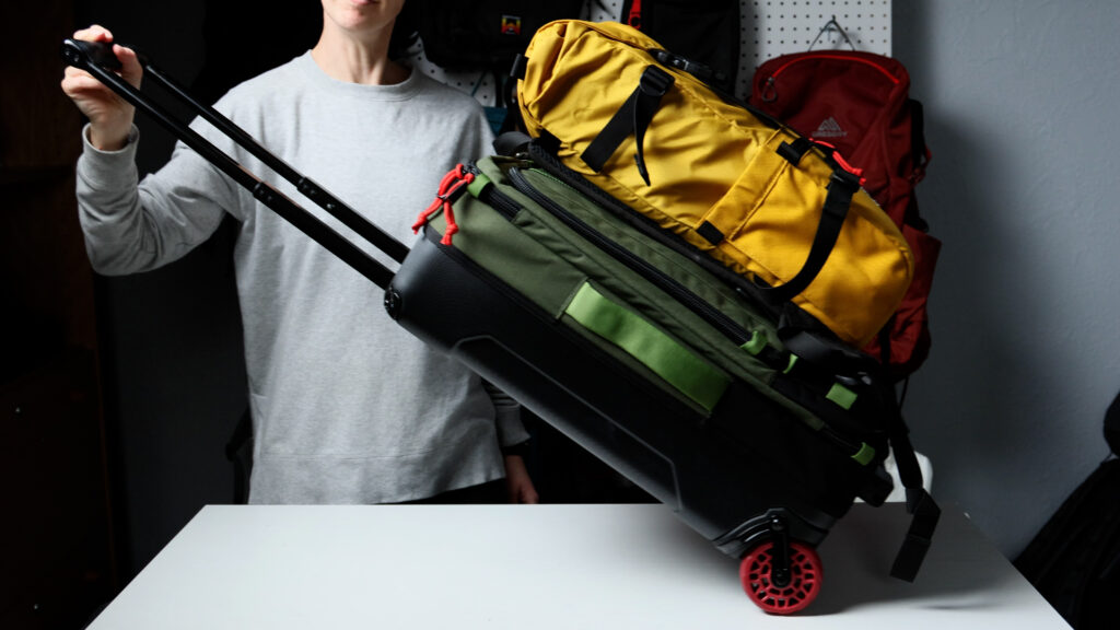 The Topo Designs Rover Classic clipped to the front of the Global Traveler carry-on luggage.
