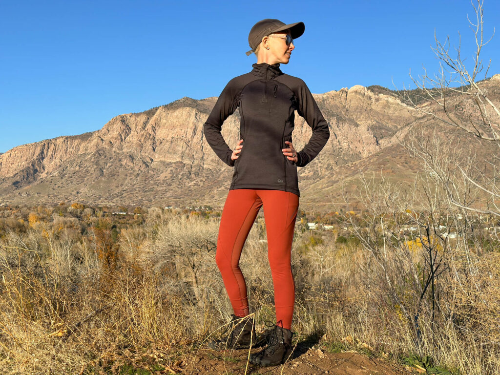 A woman poses on a hiking trail. She is wearing Outdoor Research Ferrosi hybrid leggings.