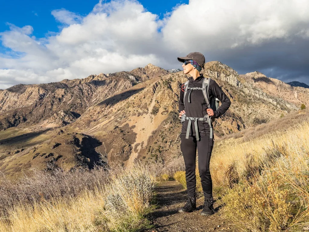 A woman poses on a hiking trail. She is wearing Patagonia Pack Out tights.
