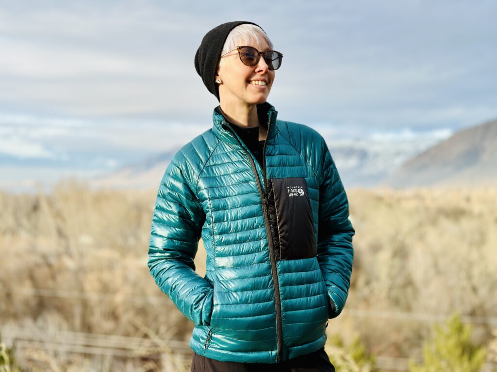 A woman wears the Mountain Hardwear Ventano insulated jacket outdoors on a trail.