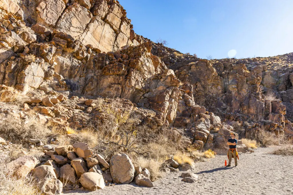 Sloan Canyon Conservation Area: A man looks up at tall, rocky cliffs