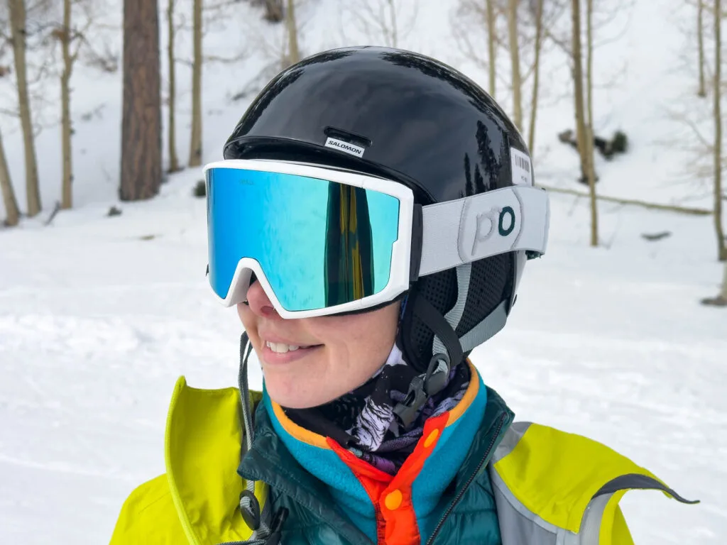 A woman in a snowboard helmet wears the Opolis Ski & Snowboard Goggles.