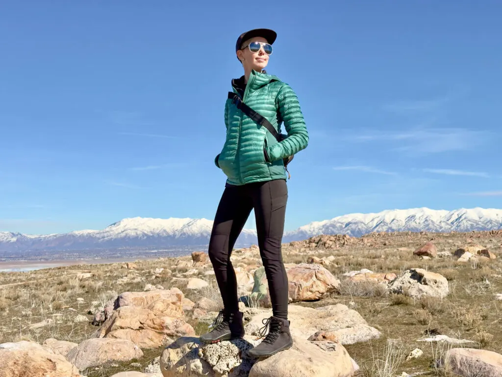 a woman stands in front of mountains wearing the mammut Zinal Hybrid tights leggings.