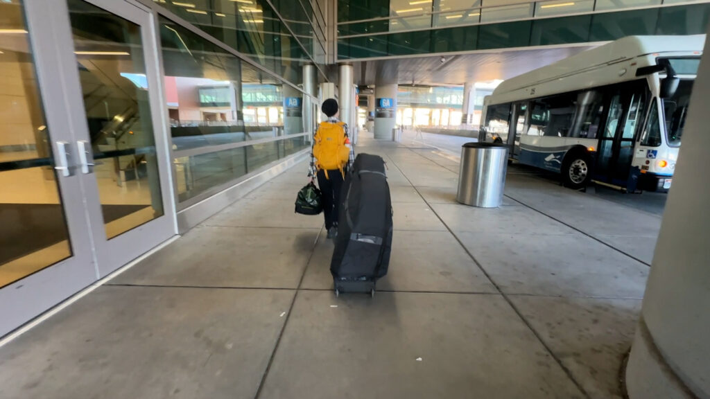 Walking outside the airport with the Dakine Bike Roller Bag. 